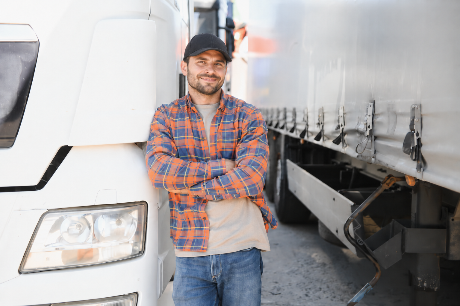 Owner-operator standing beside his semi truck and trailer
